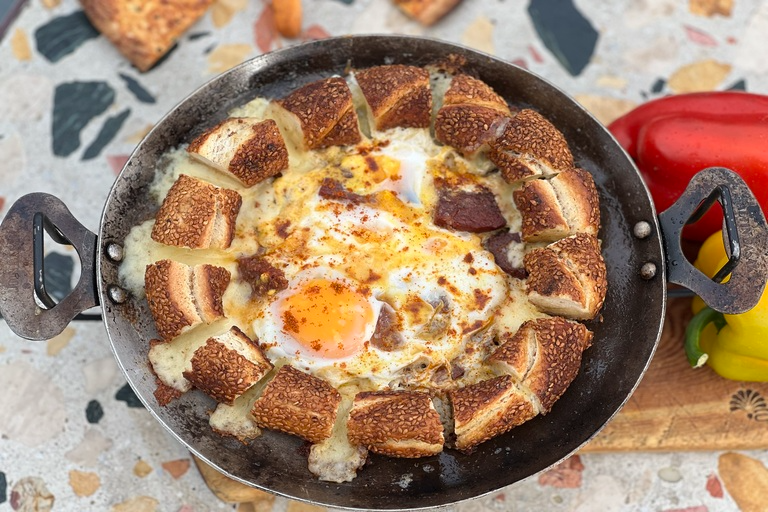Pan-fried eggs with kaşar and sucuk, served with simit