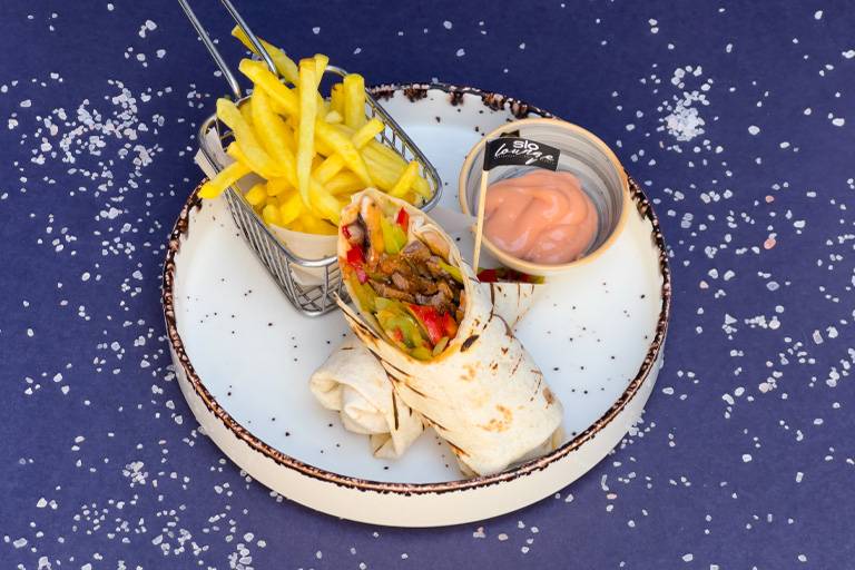 Meat wrap with dipping sauce and fries