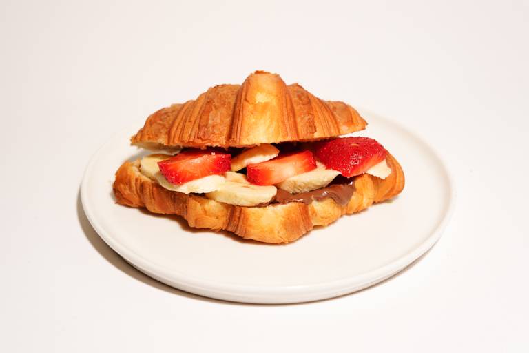 Sweet croissant sandwich with chocolate, banana and walnuts